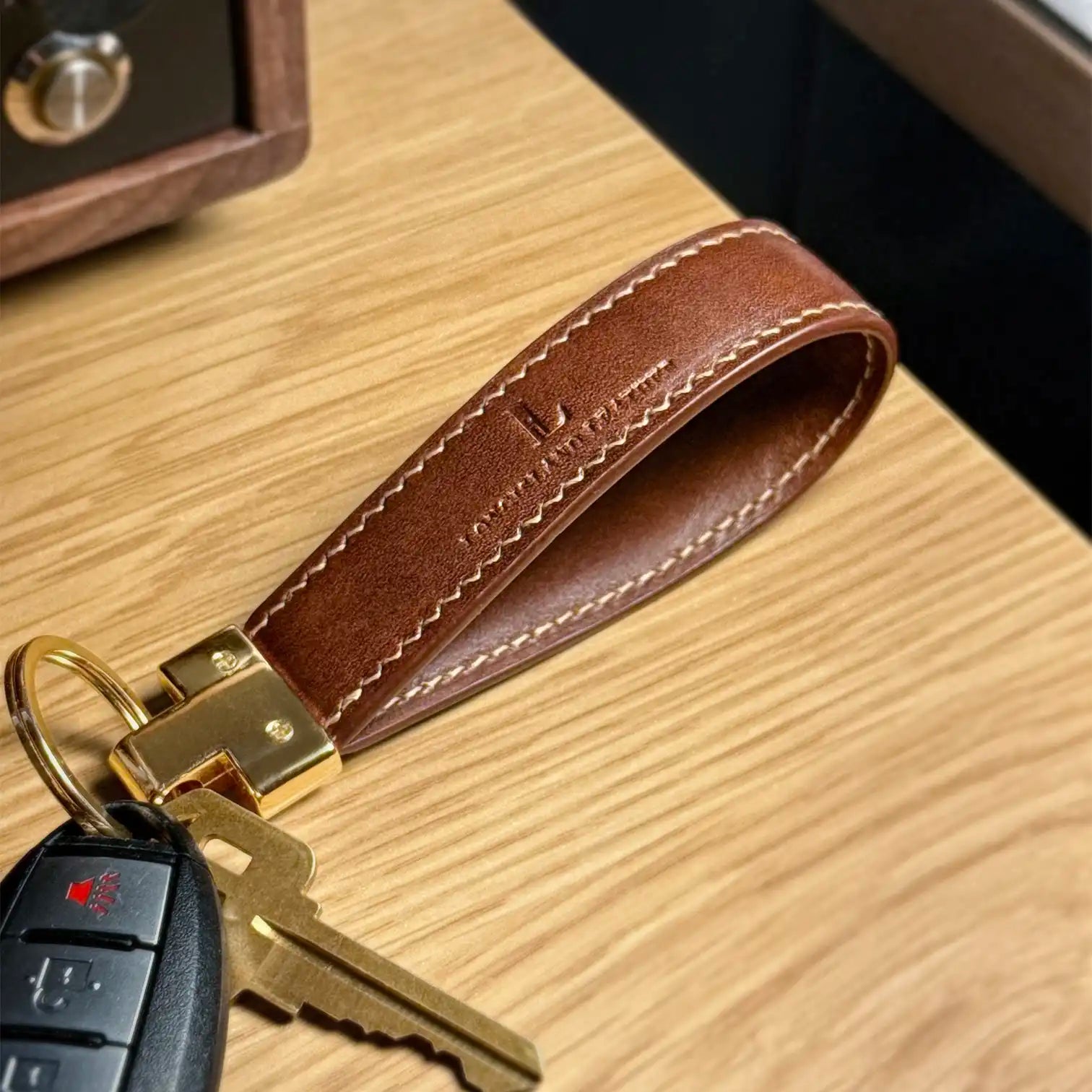 Essen key fob made with vegetable tanned leather in brown, on table, hooked with keys