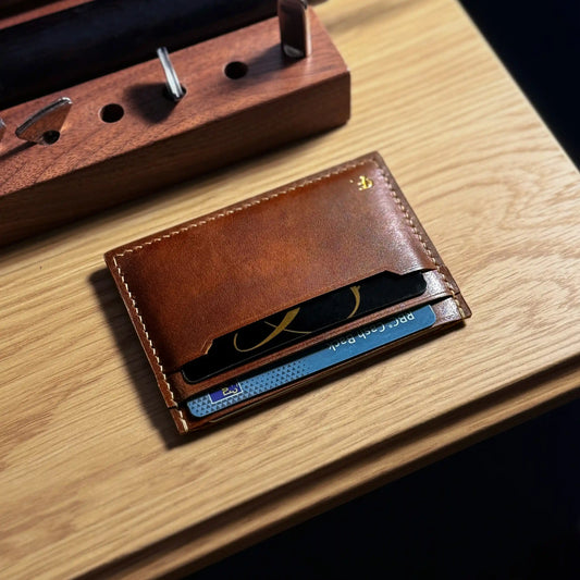 Brown leather cardholder on a wooden surface, front view