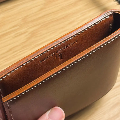 Close-up of the burnished edge and precision stitching on the classic bifold leather wallet.