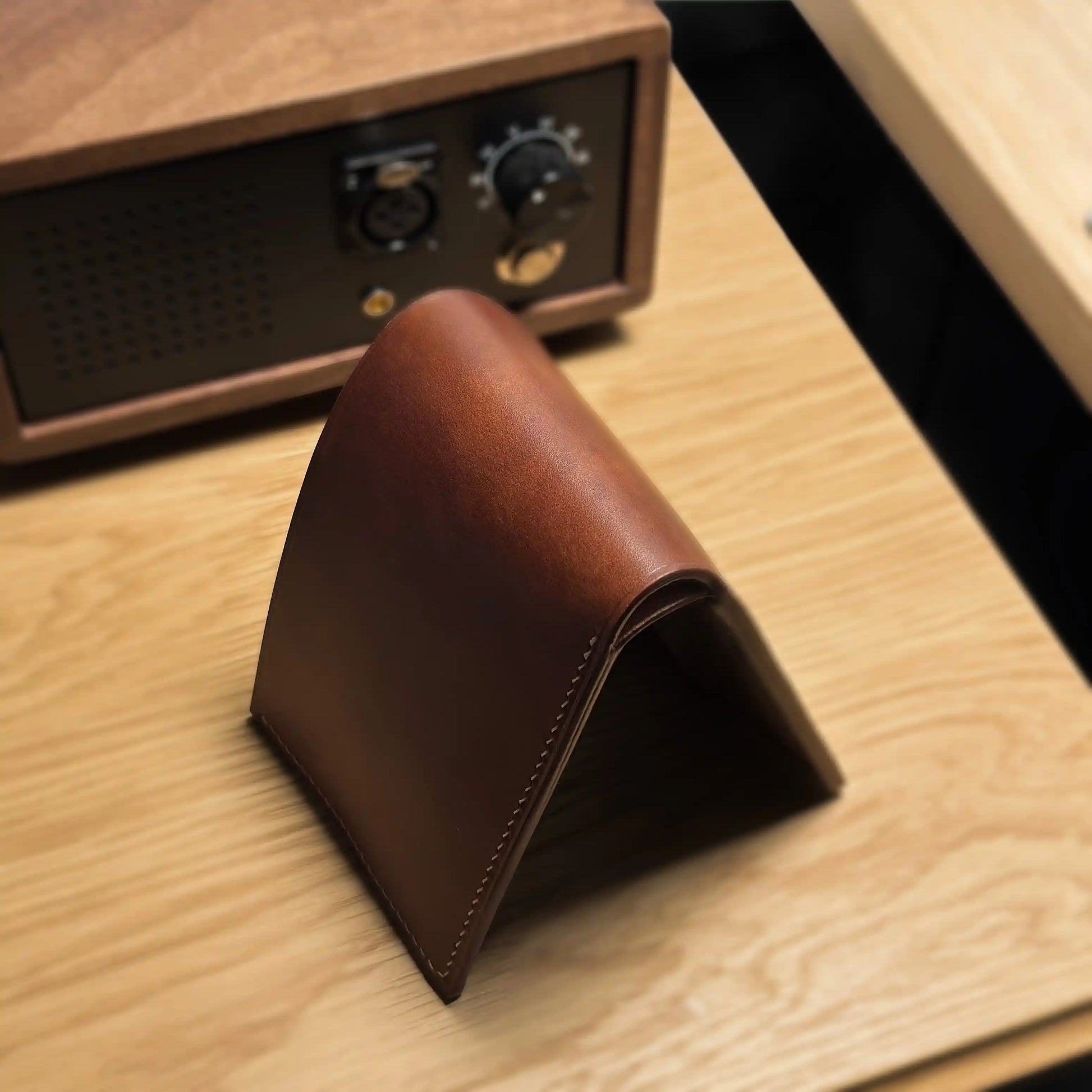 Side view of the classic bifold leather wallet on a wooden surface, highlighting its slim and durable profile.