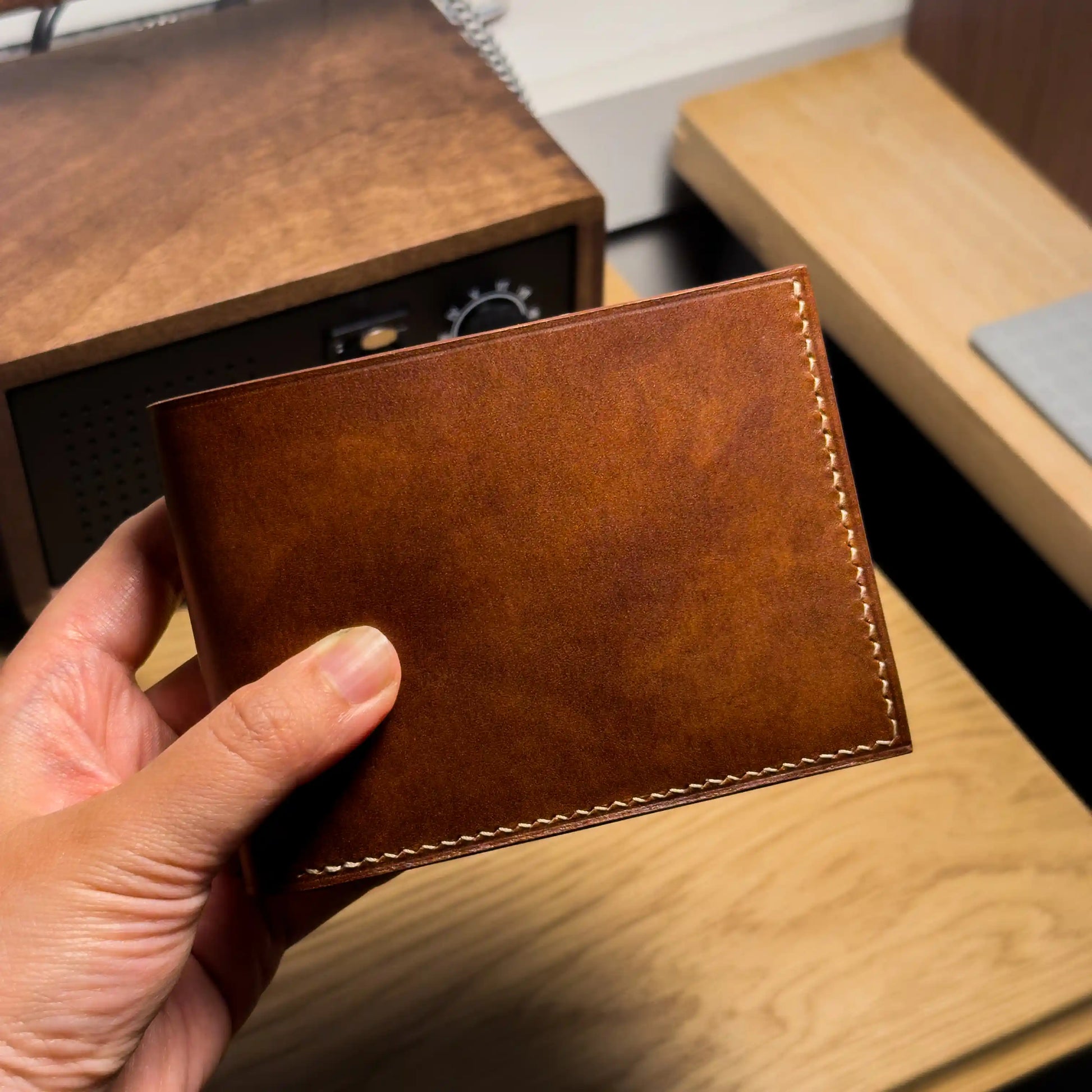 An artisan holding the classic custom leather wallet, an ideal personalized gift for him.