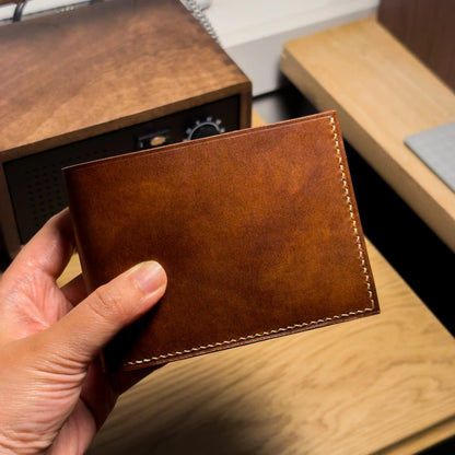 An artisan holding the classic custom leather wallet, an ideal personalized gift for him.