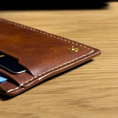 Close-up of traditional saddle stitching on a vegetable-tanned leather card holder