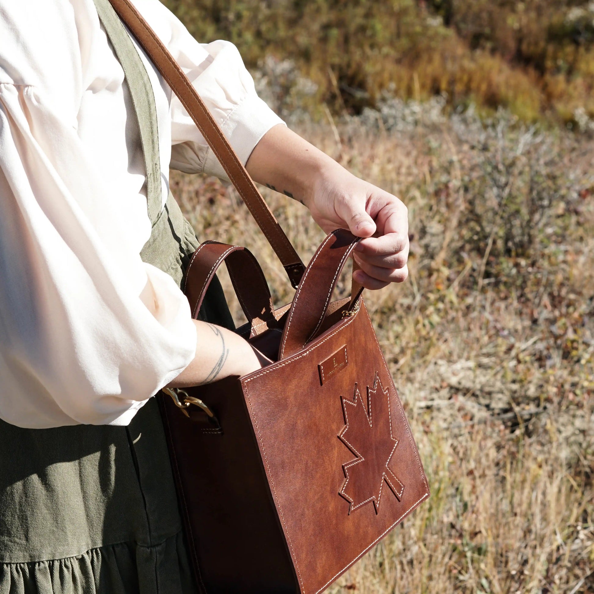 Opening the Maple Heritage handcrafted leather handbag to showcase its roomy interior for daily essentials