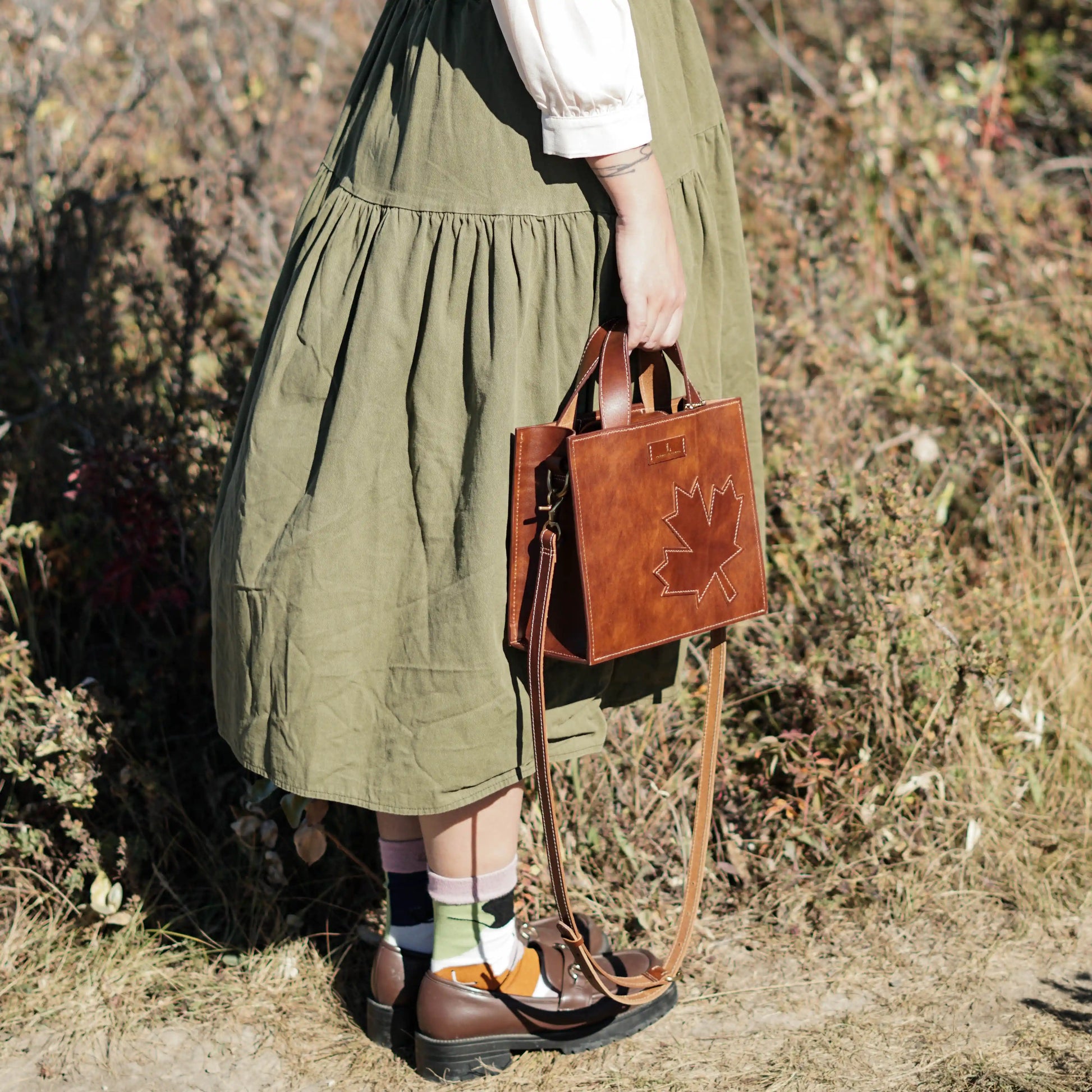 A model styling the Maple Heritage leather crossbody bag, highlighting its elegant size and proportions.
