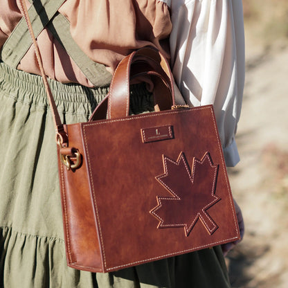 Close-up of the signature maple leaf pattern on the handcrafted heritage leather bag.
