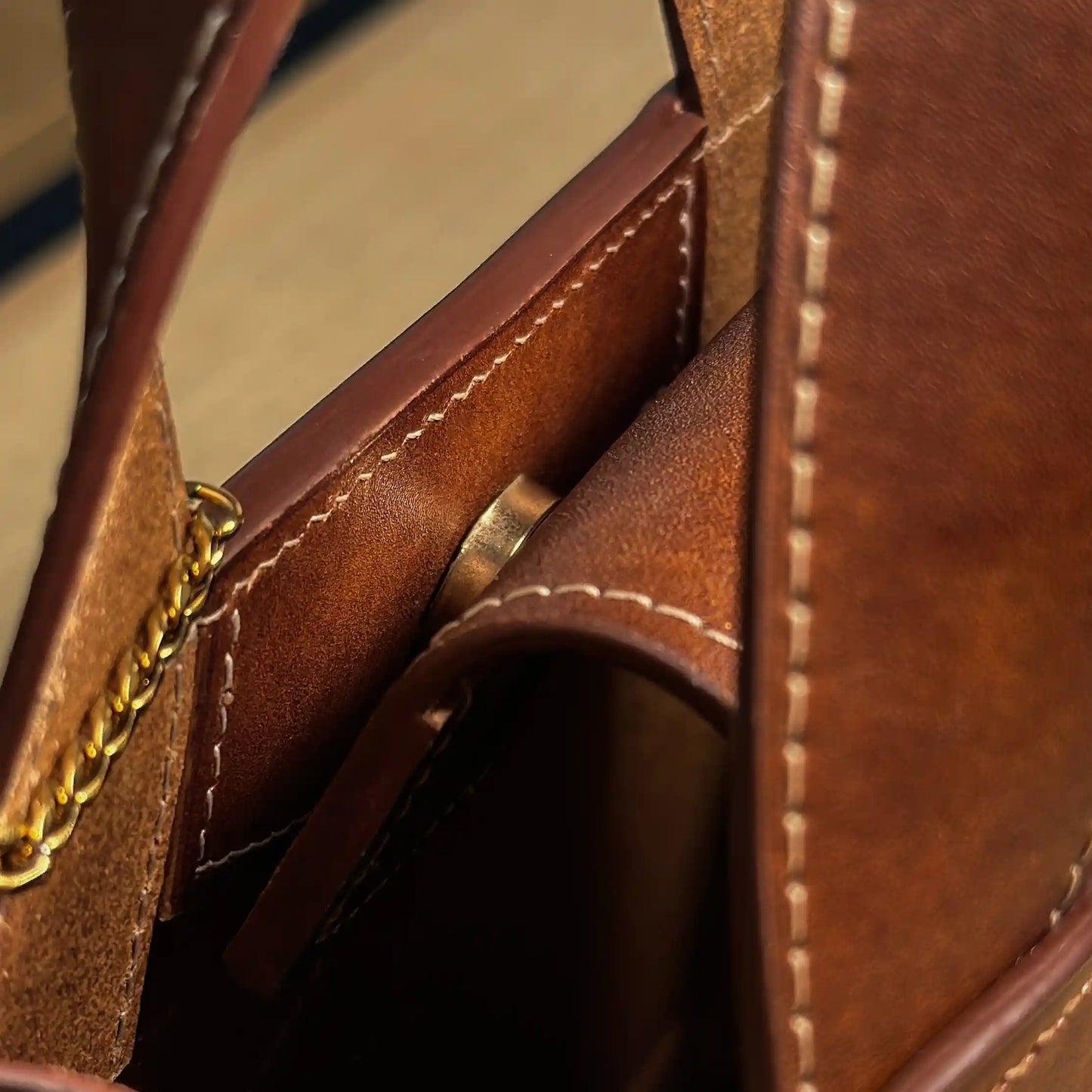 Close-up of the secure magnetic closure and premium golden chain detail on the Maple leather bag
