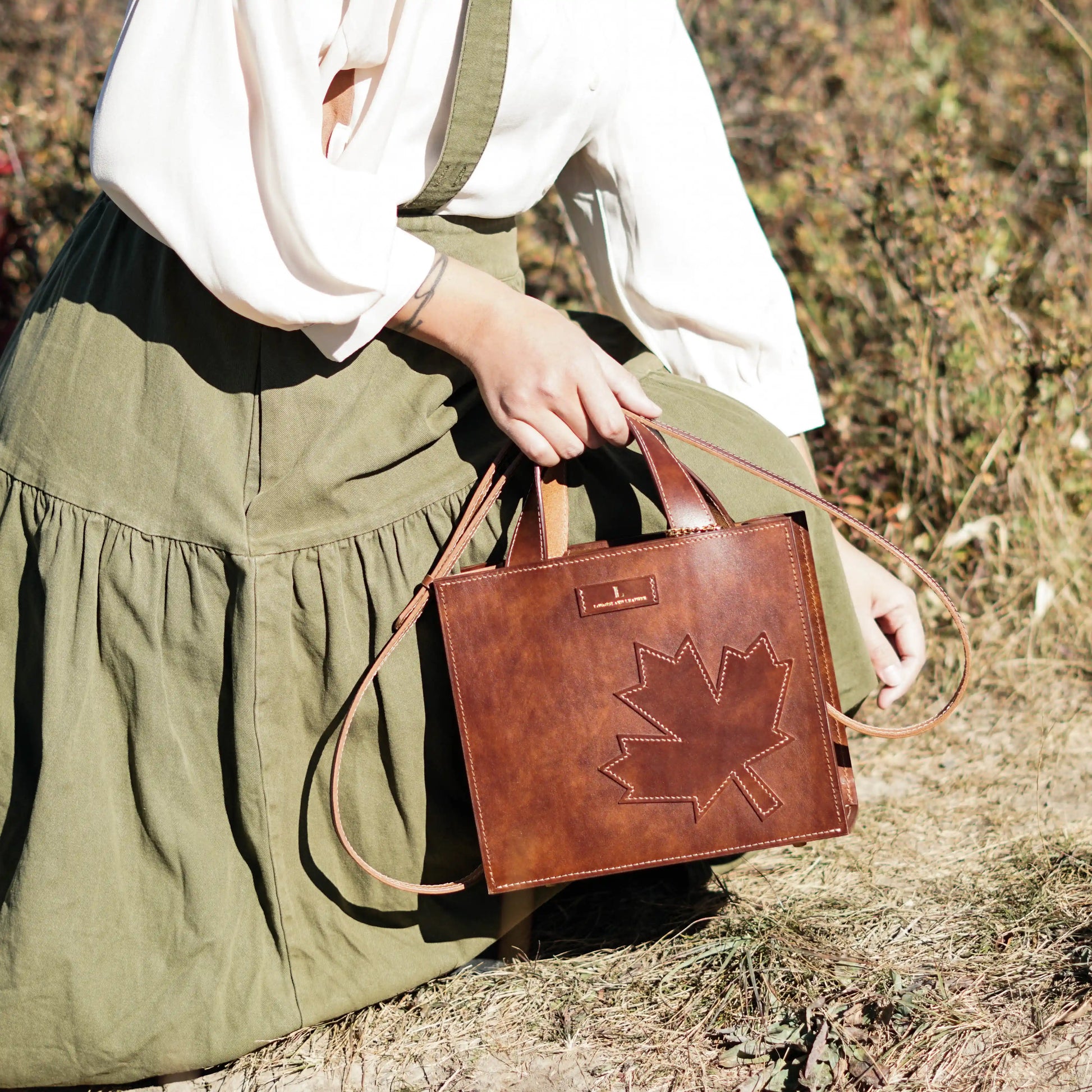 Front view of the Maple leather handbag featuring a signature maple leaf design
