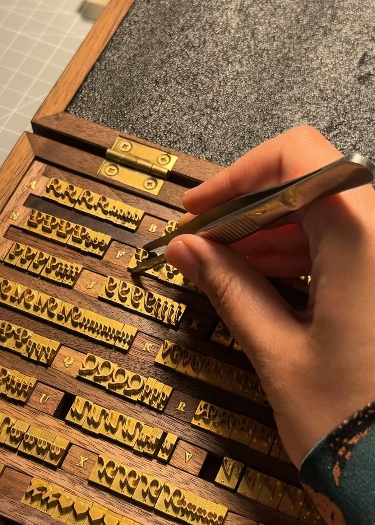 A leather artisan in Calgary making the EVERYDAY leather card holder for Longisland Leather, personalized with a golden stamping name initial.