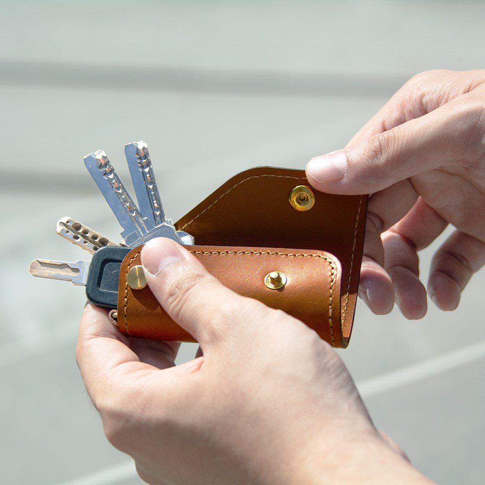 Using the SIDECAR leather key holder to access keys. Designed as a minimalist and silent key organizer to protect your phone