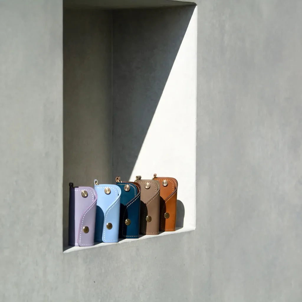 A collection of SIDECAR leather key organizers in various colors including Lavender, Blue, and Navy, handcrafted in Canada.