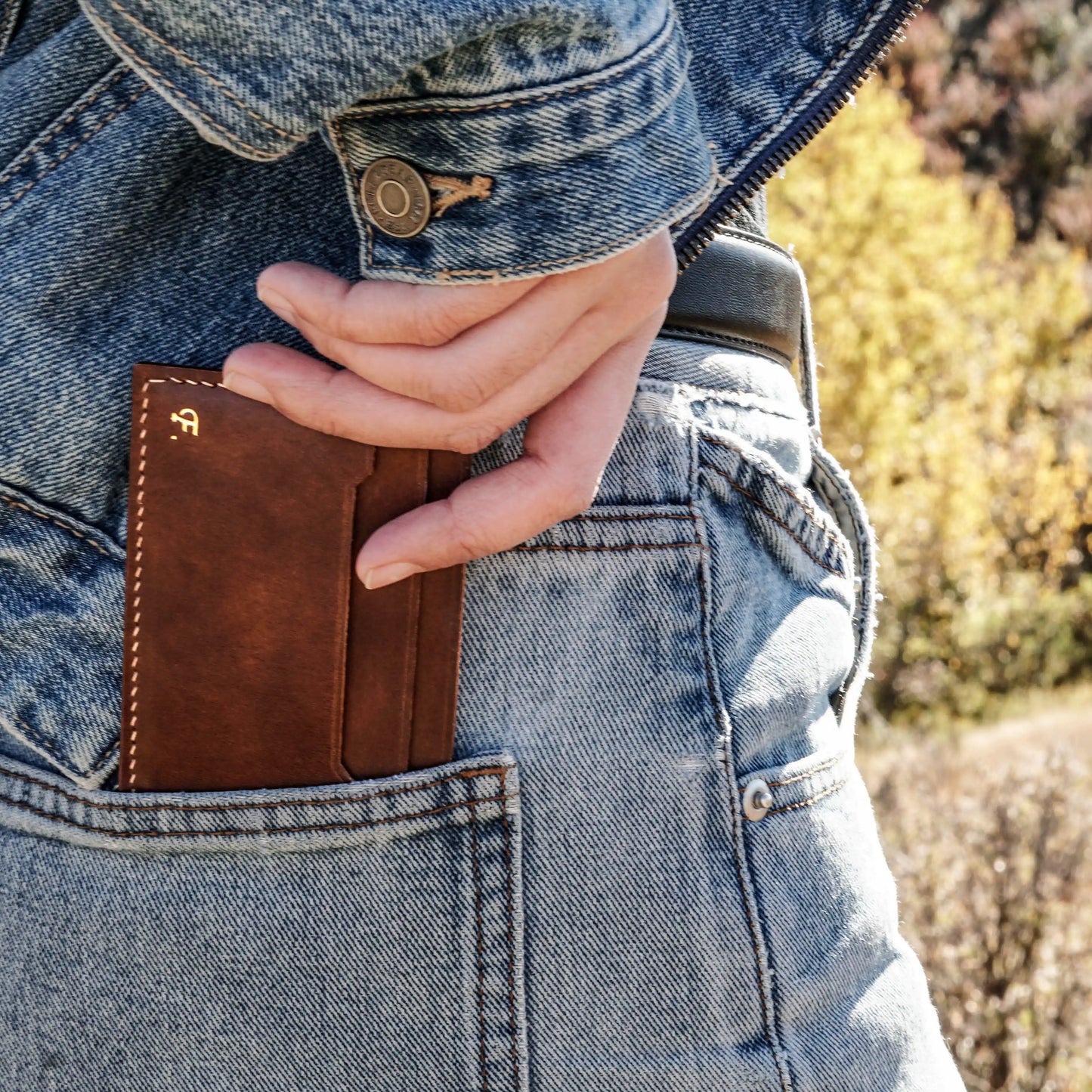 The Minimalist slim leather wallet for men fitting perfectly in a denim back pocket.