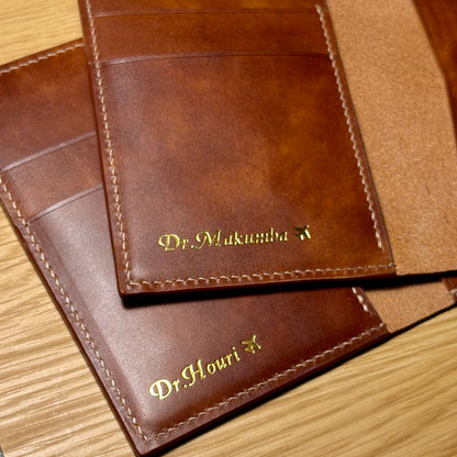 Close-up of gold personalized names and airplane motifs on brown leather passport covers